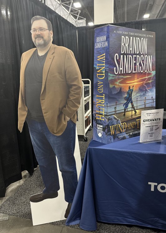 cardboard cutout of Brandon Sanderson next to a large cardboard cut out of his new book Wind and Truth